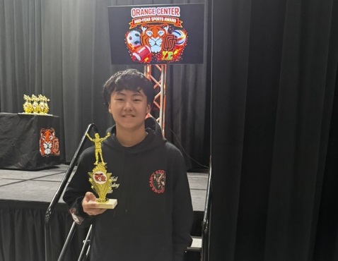 a male student holding a trophy 