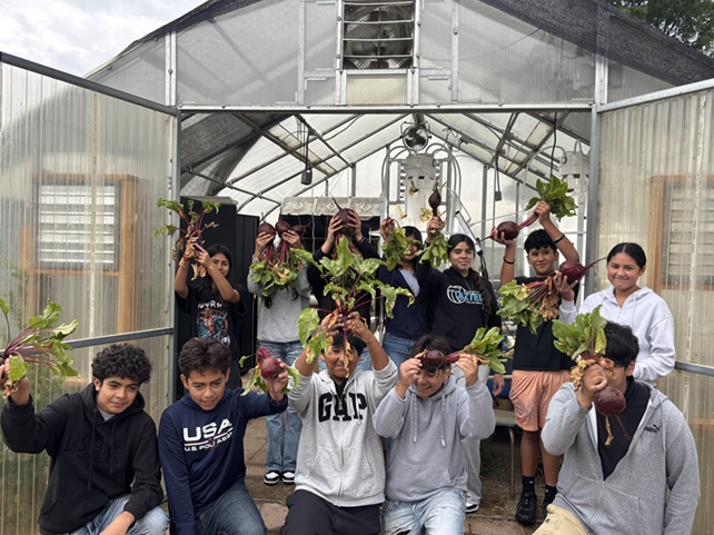 students in the garden holding plants