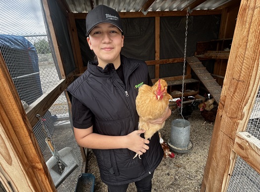 male student holding a chicken 