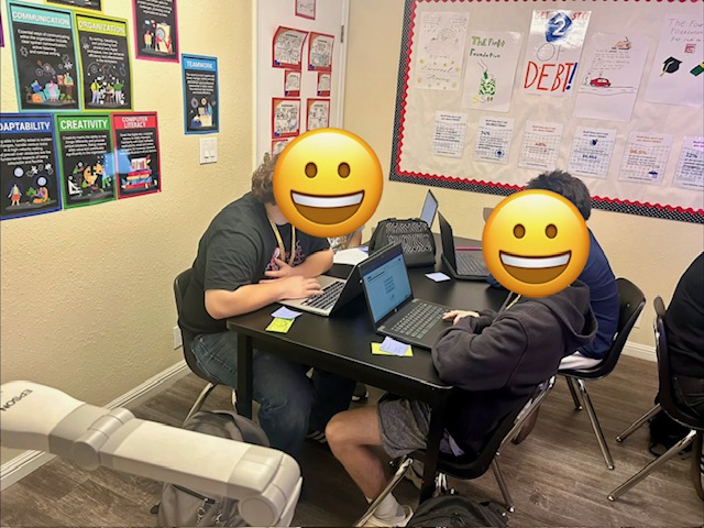 two students working on laptops