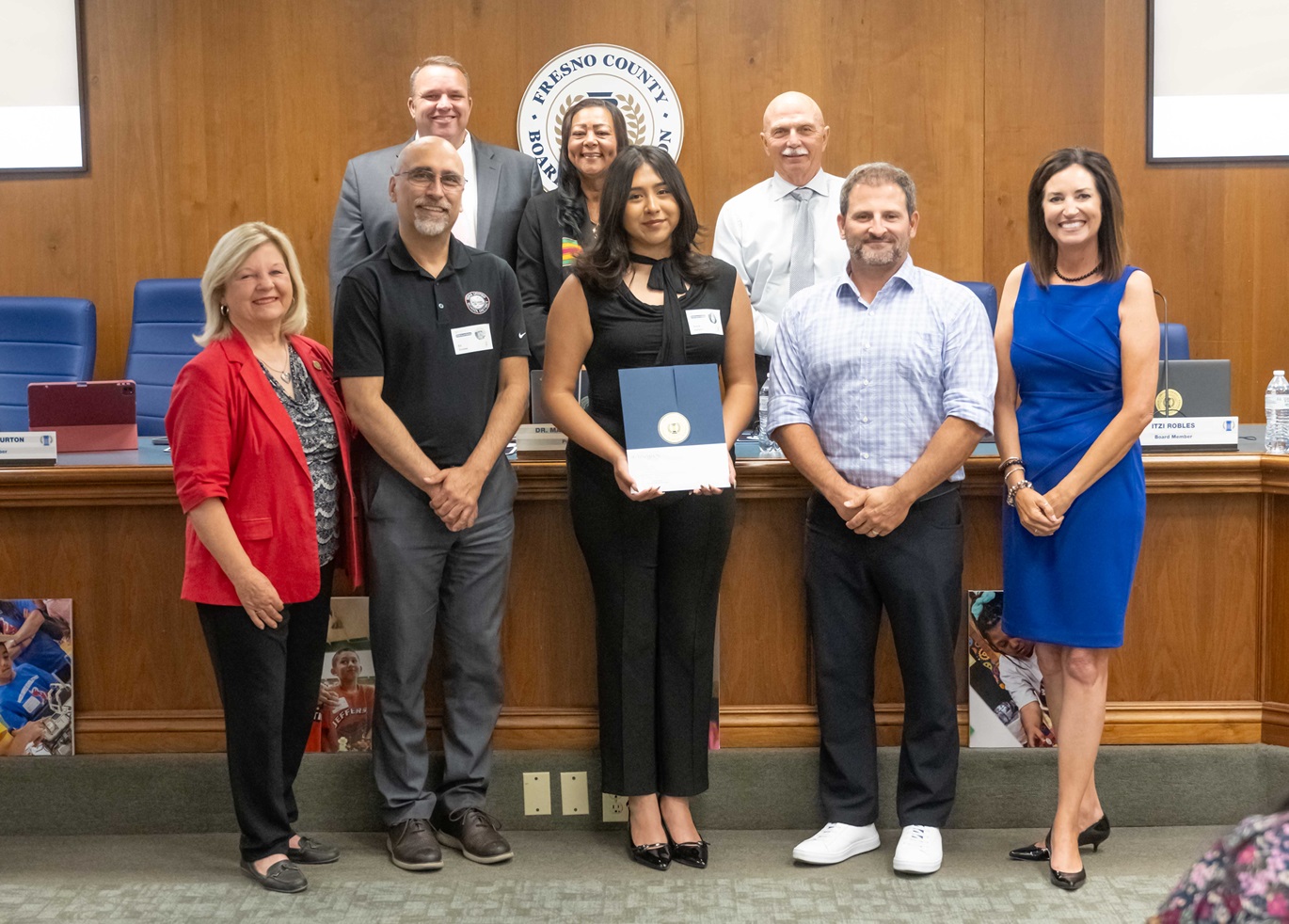 Student standing with certificate recognizing her as the Superintendent Superstar with her teachers and Fresno County board of education.