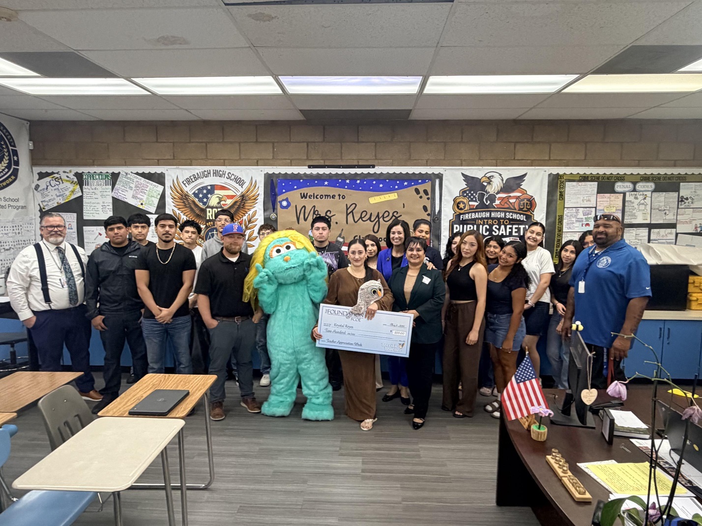 Students and staff gather as Rosita character surprises a Terrific Teacher with a classroom celebration and recognition award.