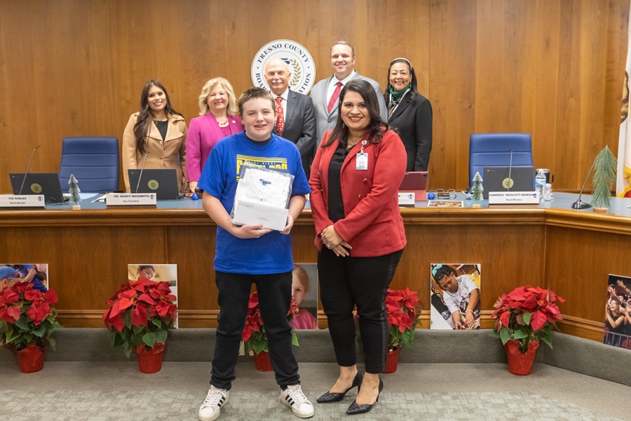 A student poses with Deputy Superintendent, Dr. Diane Lira during a board meeting